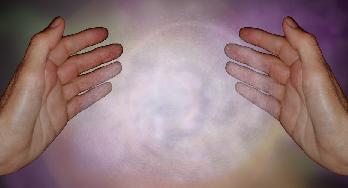 Reiki hands with white energy between them